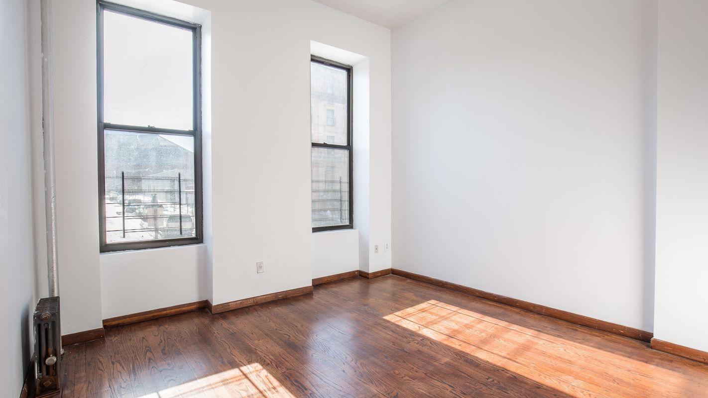 27 Brevoort Place, Unit 2 Brooklyn, NY 11216 - Photo 5 of 9 an empty room with wooden floor and windows