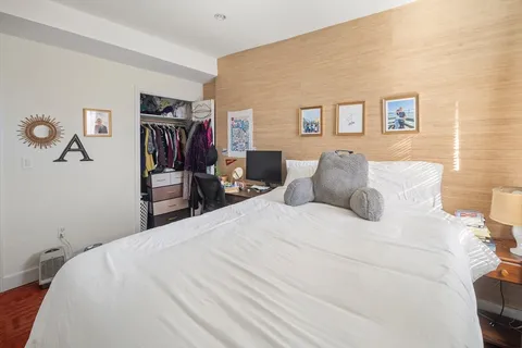 a large bed sitting in a bedroom and a book shelf