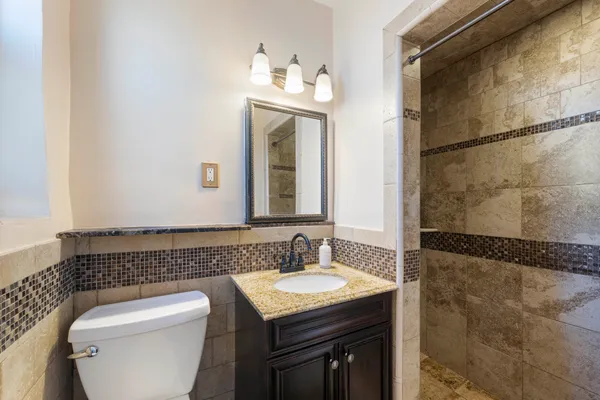 a bathroom with a granite countertop sink toilet and shower