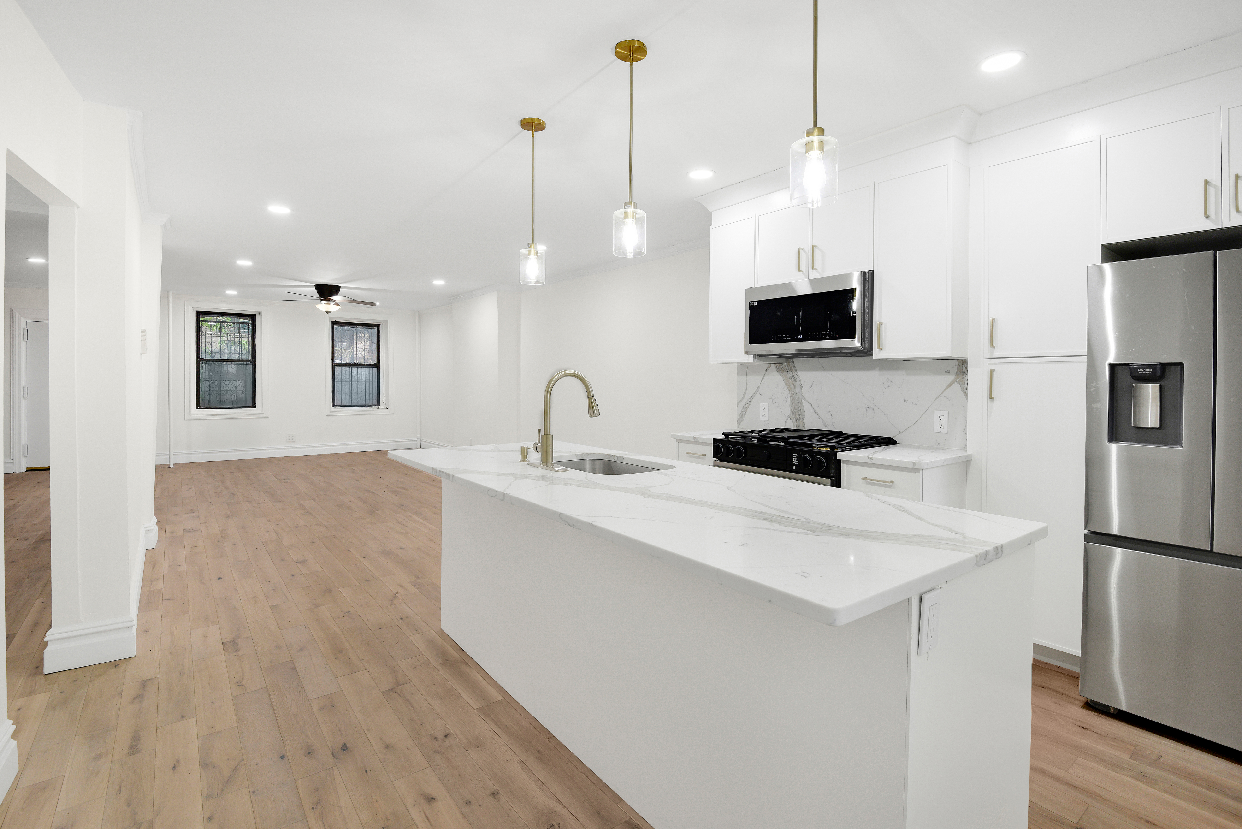 615 Willoughby Avenue, Unit 1 Brooklyn, NY 11206 - Photo 2 of 13 a kitchen with kitchen island a sink stainless steel appliances and white cabinets