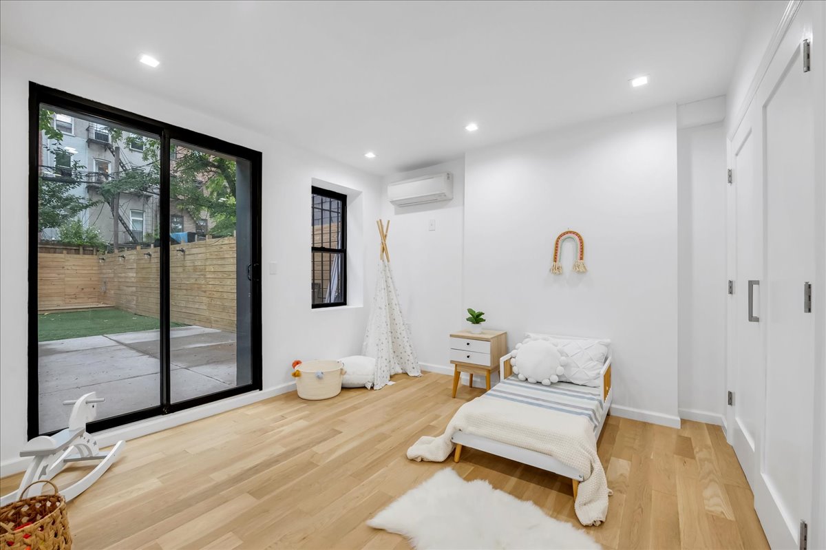 448 Halsey Street, Unit 1 Brooklyn, NY 11233 - Photo 14 of 22 a bedroom with a large bed and a large window