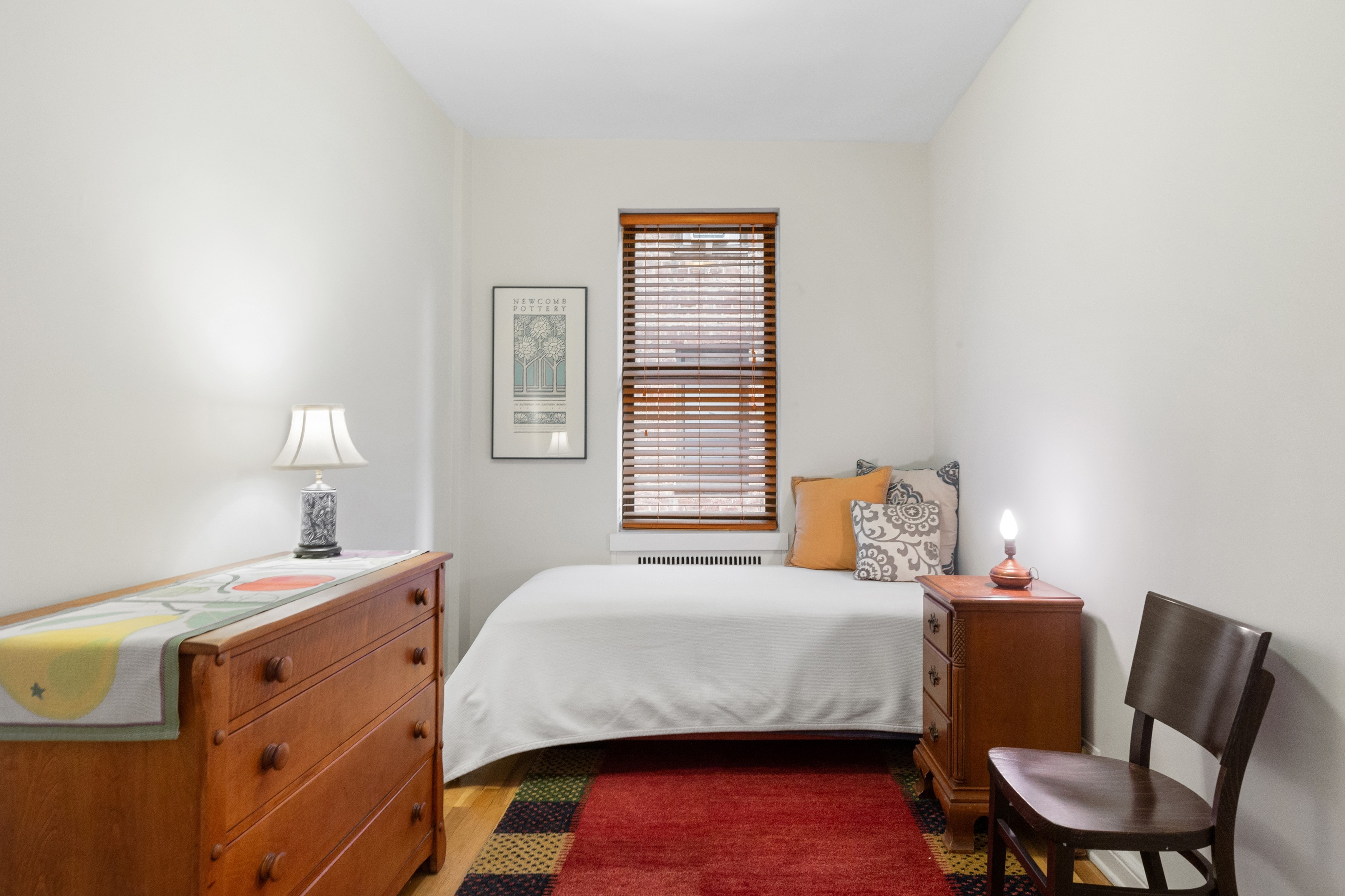 159-00 Riverside Drive West, Unit 5D Manhattan, NY 10032 - Photo 8 of 19 a bedroom with a bed and a chair with wooden floor