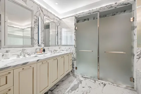 a bathroom with a double vanity sink mirror and shower