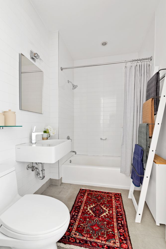 360 Furman Street, Unit 906 Brooklyn, NY 11201 - Photo 5 of 7 a bathroom with a sink a toilet a mirror and shower