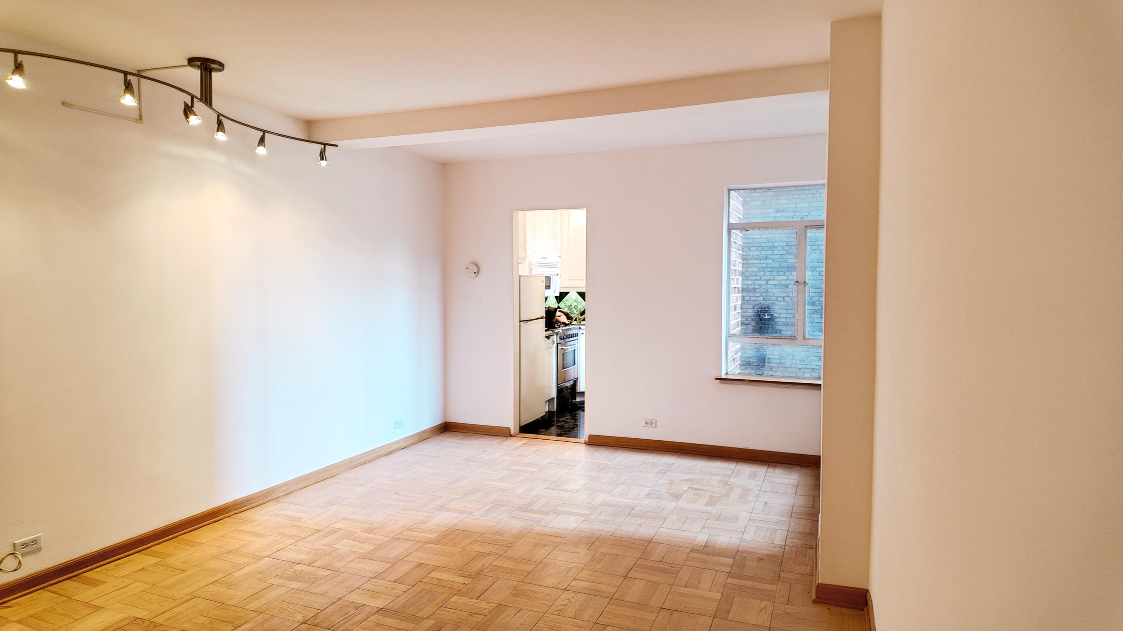 750 Park Avenue, Unit 8D Manhattan, NY 10021 - Photo 4 of 14 a view of a room with wooden floor and windows