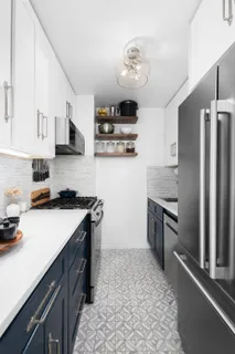 a kitchen with stainless steel appliances granite countertop a refrigerator a stove and a sink with wooden floor