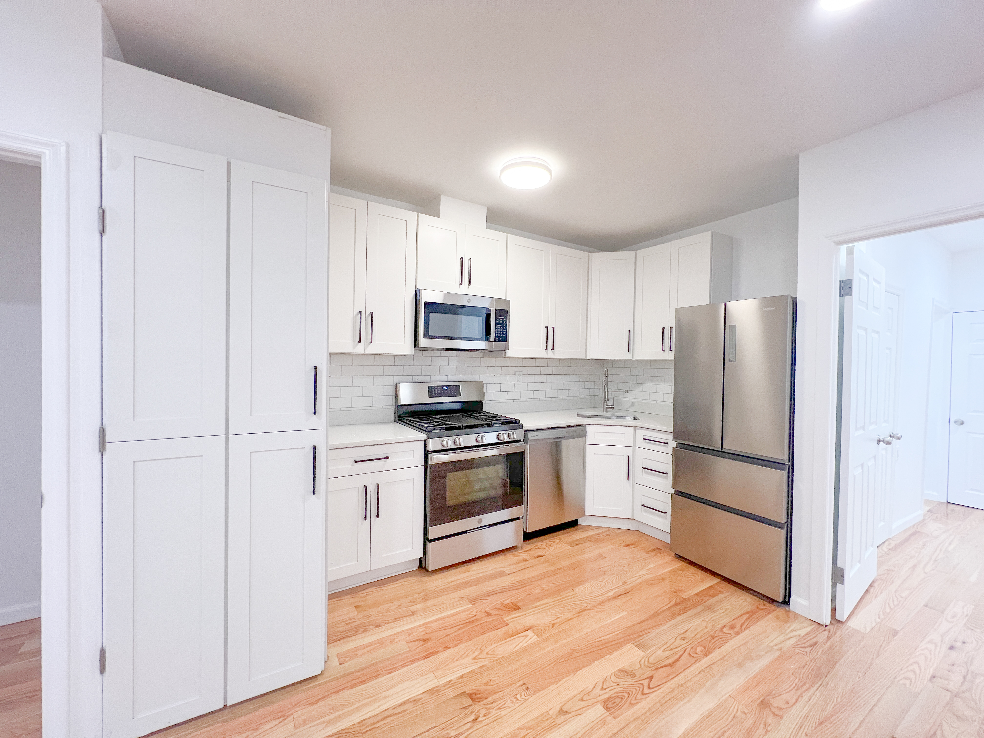 955 Pacific Street, Unit 1 Brooklyn, NY 11238 - Photo 3 of 12 a kitchen with white cabinets and stainless steel appliances