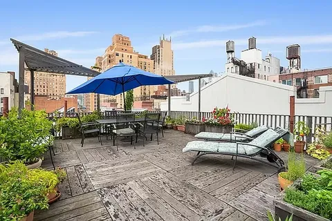 a view of a terrace with furniture and umbrella