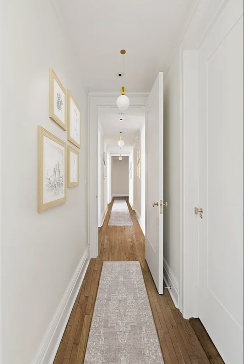 905 West End Avenue, Unit 112 Manhattan, NY 10025 - Photo 4 of 12 a view of a hallway with wooden floor and a bathroom