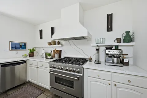 a kitchen with white cabinets and appliances