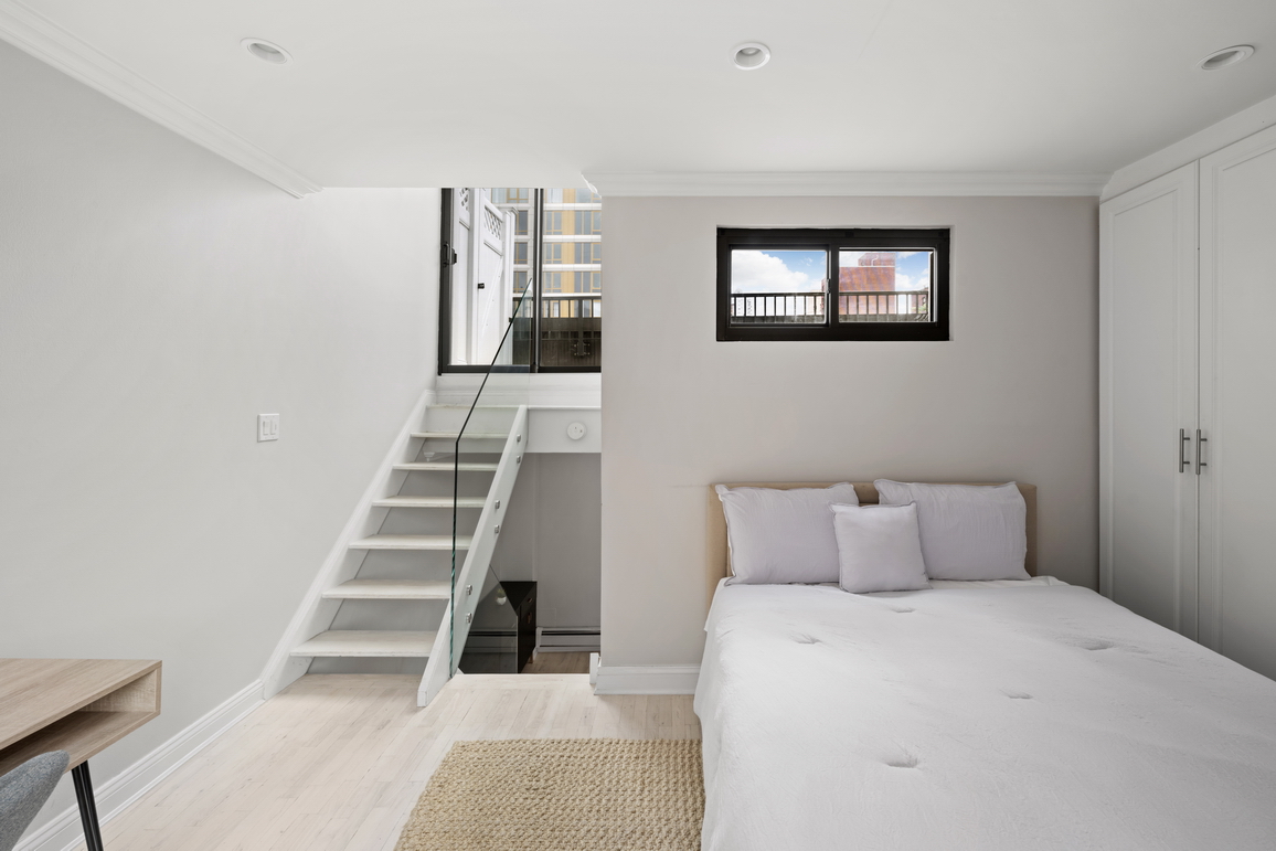 160 East 26th Street, Unit 6B Manhattan, NY 10010 - Photo 7 of 10 a bedroom with a bed and white walls