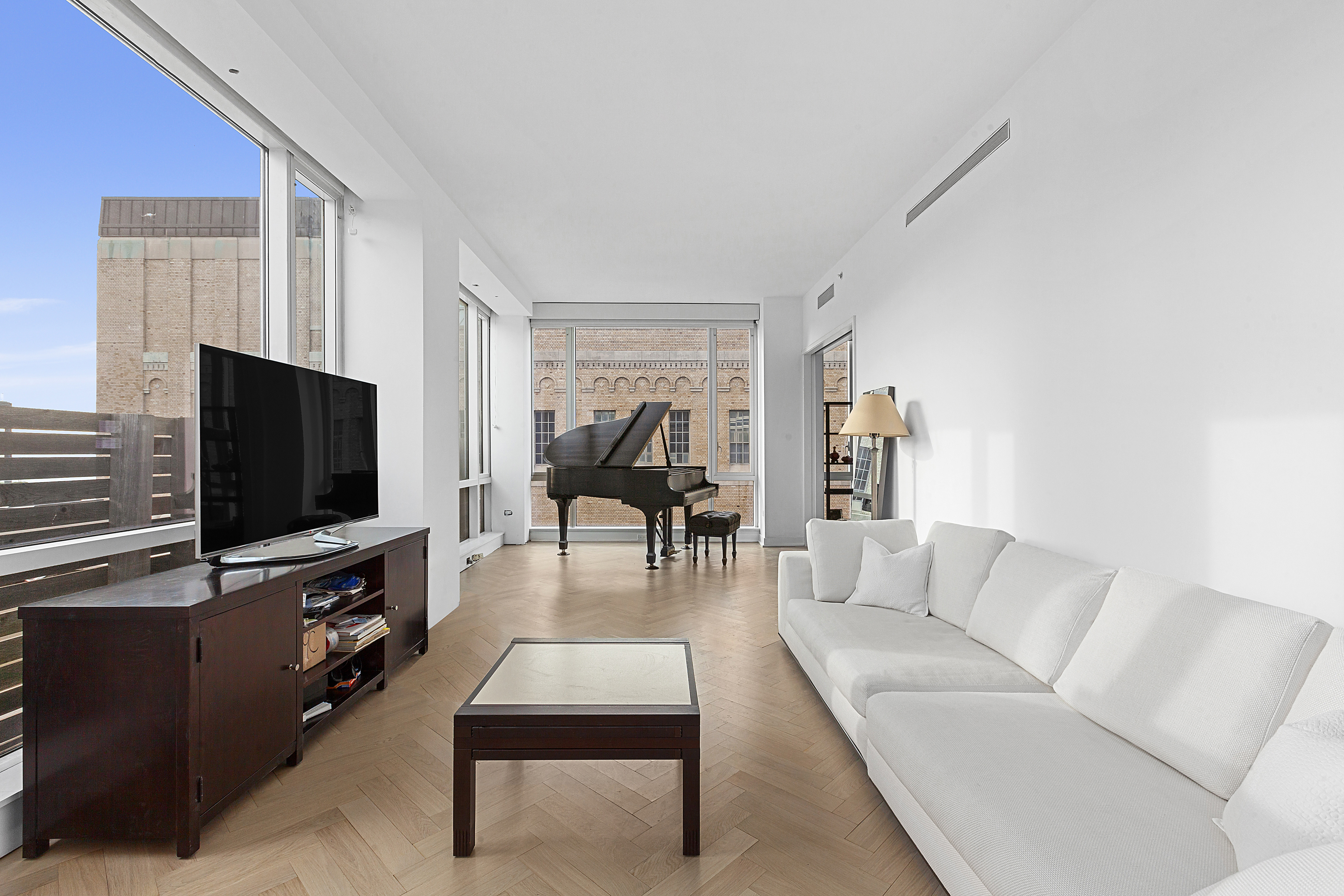 330 Spring Street, Unit 9C Manhattan, NY 10013 - Photo 3 of 8 a living room with furniture and a flat screen tv