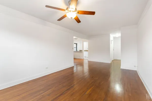 a view of empty room with wooden floor
