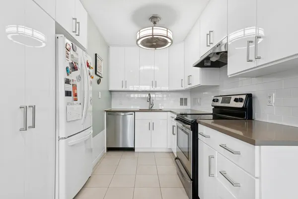 a kitchen with stainless steel appliances granite countertop a sink a stove and cabinets