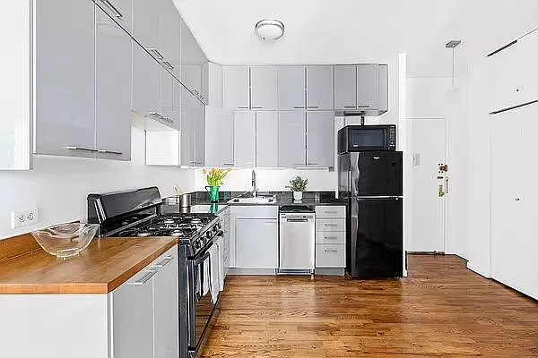 604 Riverside Drive, Unit 4E Manhattan, NY 10031 - Photo 4 of 8 a kitchen with a refrigerator a stove a sink dishwasher and a refrigerator with wooden floor