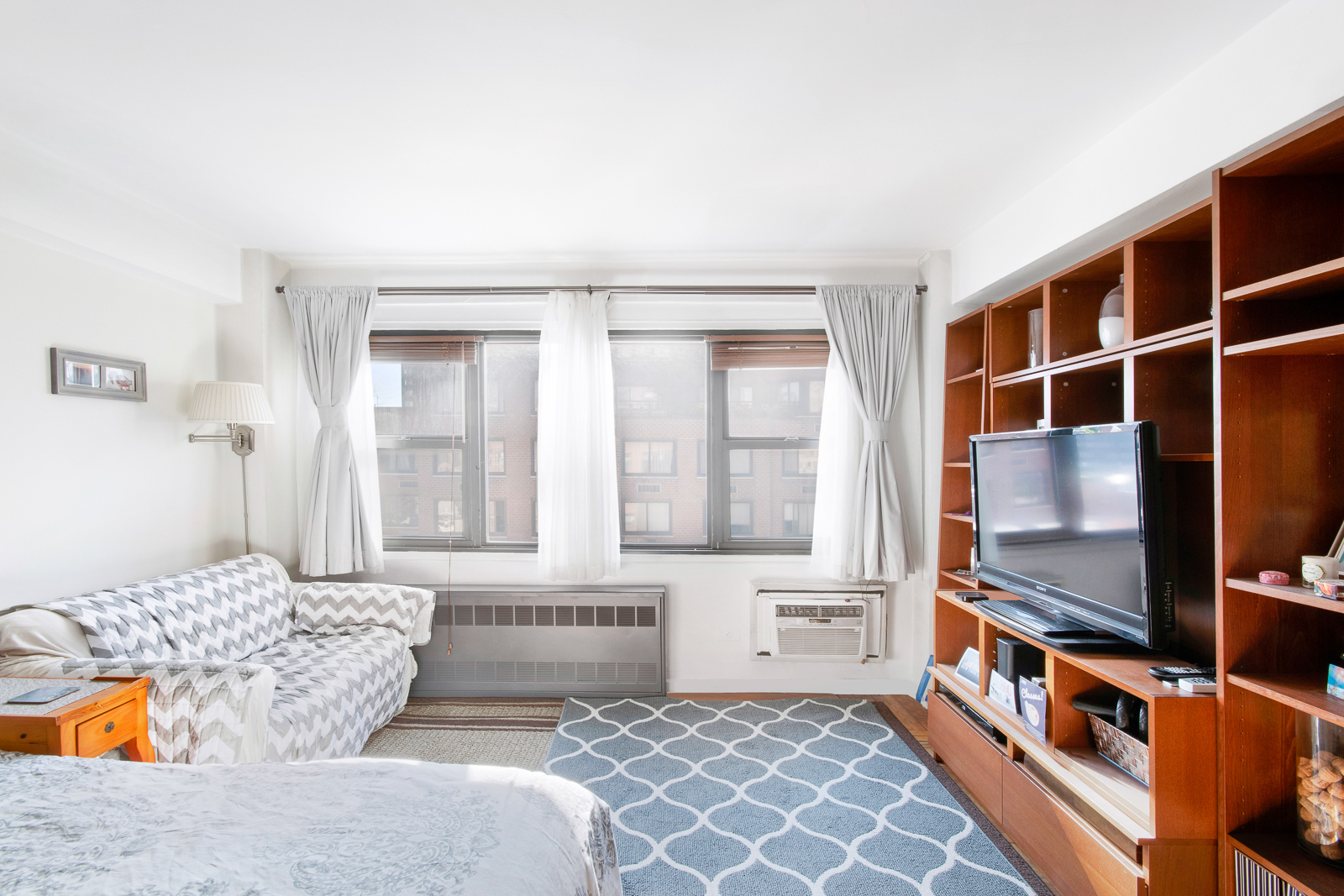 335 East 51st Street, Unit 10C Manhattan, NY 10022 - Photo 2 of 9 a living room with furniture and a flat screen tv