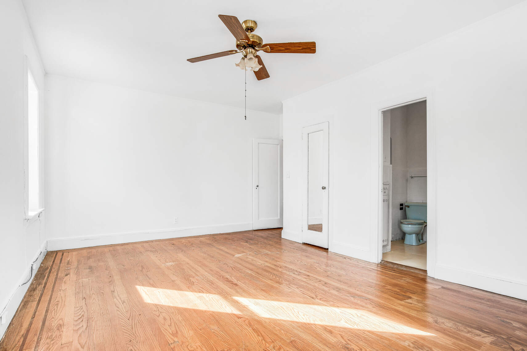 8301 4th Avenue Brooklyn, NY 11209 - Photo 7 of 20 a view of a room with wooden floor and a ceiling fan