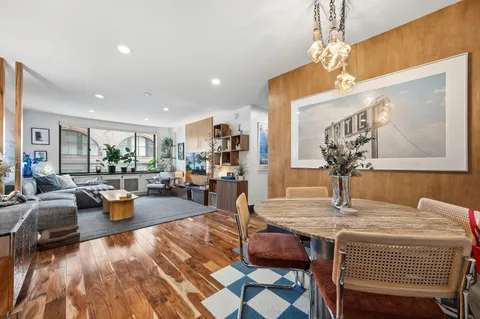 a view of a dining room with furniture a chandelier and wooden floor