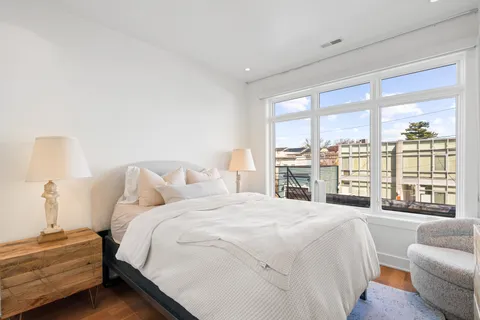 a spacious bedroom with a bed and a large window