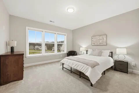 a spacious bedroom with a bed and a large window