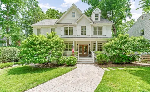 a front view of a house with a yard and trees
