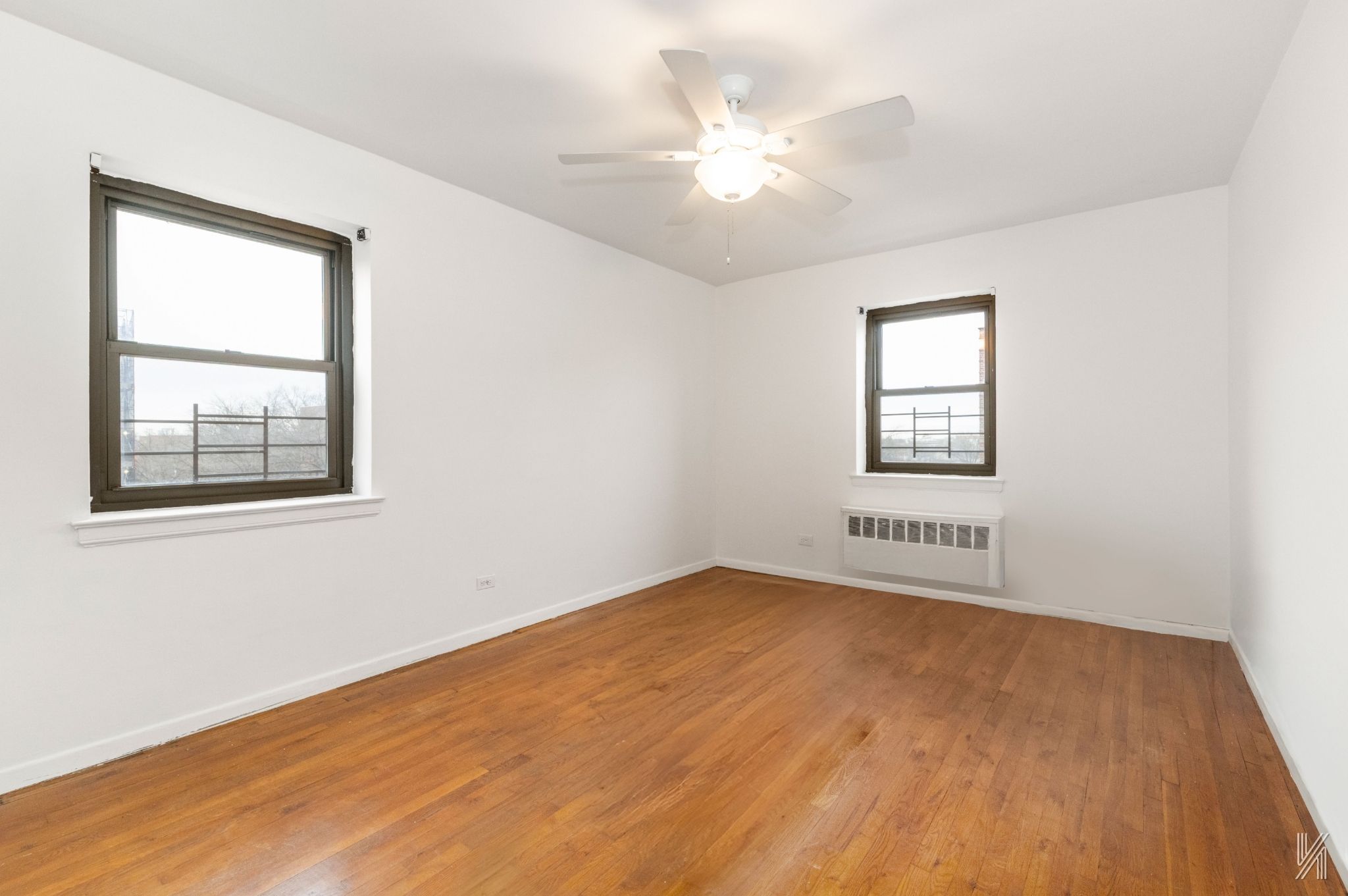 34-10 94th Street, Unit 6G Queens, NY 11372 - Photo 4 of 19 a view of an empty room with a window and wooden floor