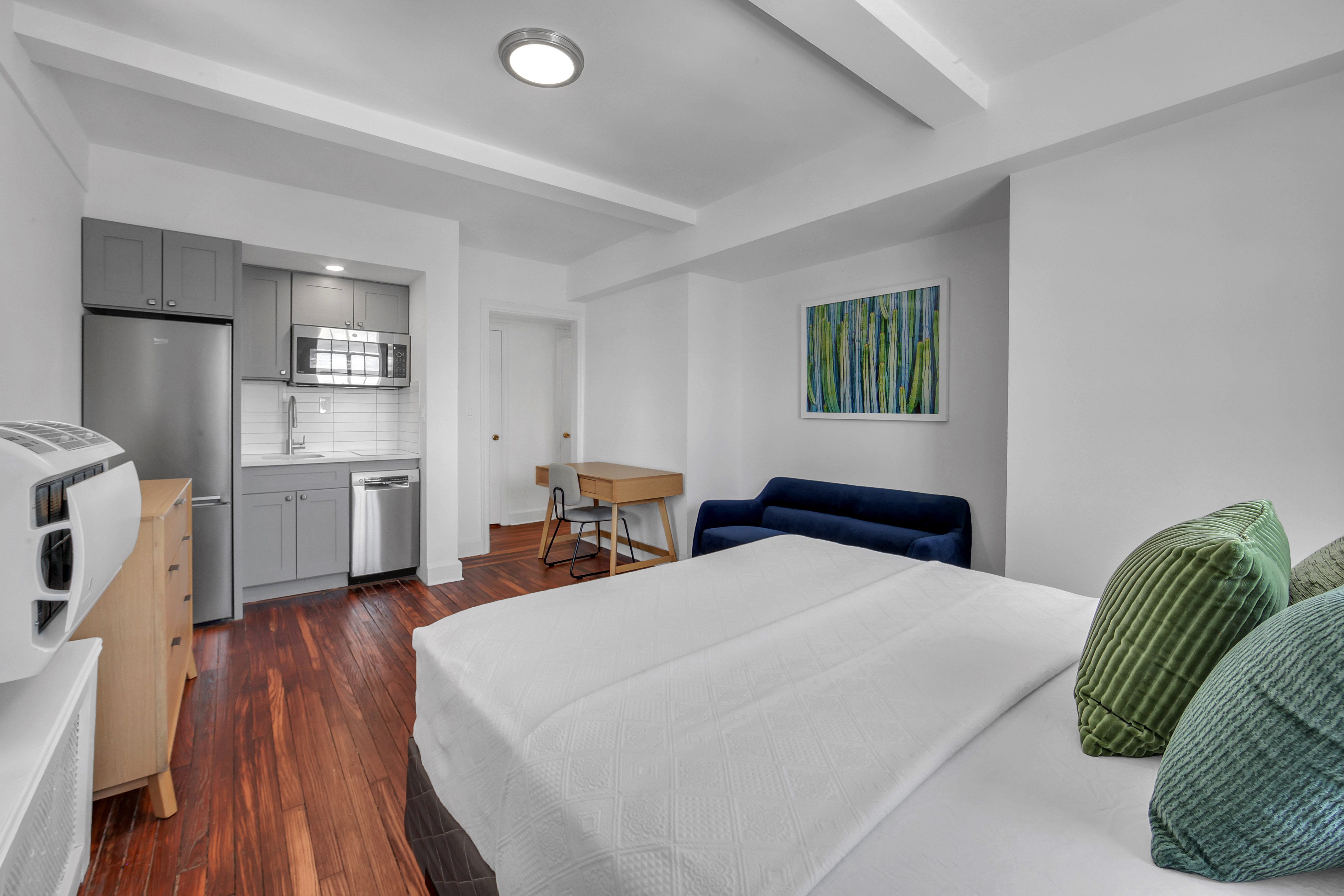 5 Tudor City Place, Unit 1536 Manhattan, NY 10017 - Photo 8 of 21 a bedroom with a bed and a couch