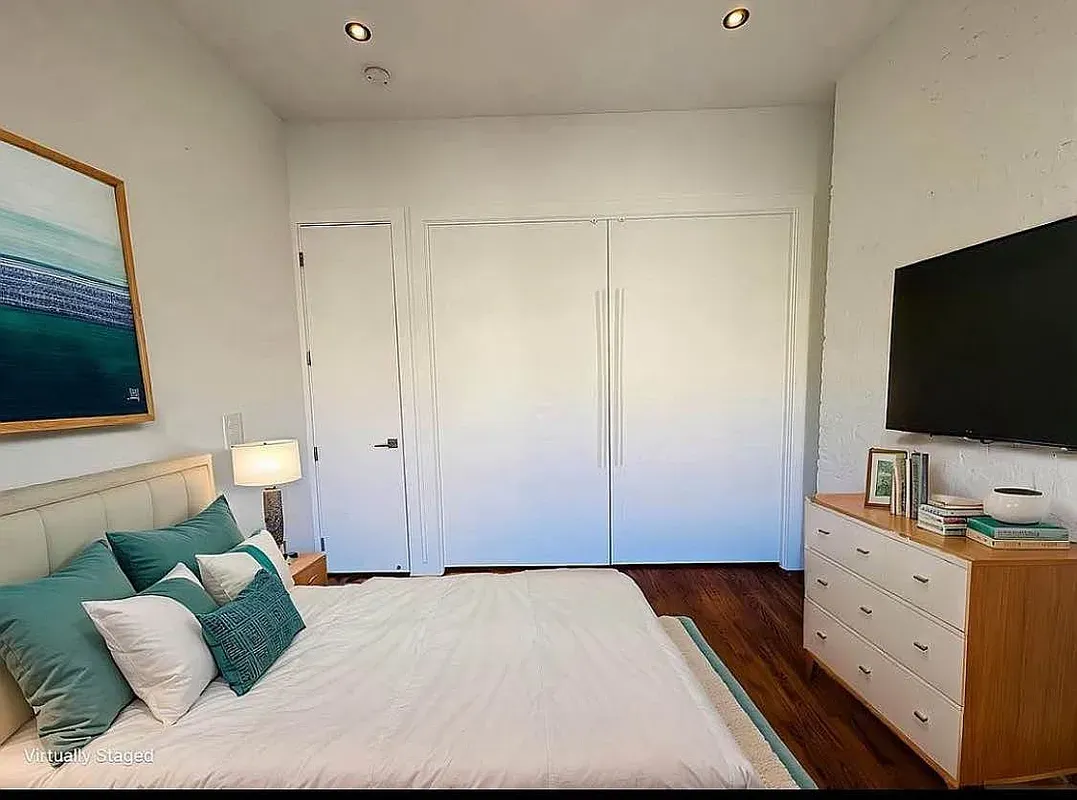 a bedroom with a bed and a potted plant