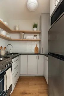 a kitchen with white cabinets and window