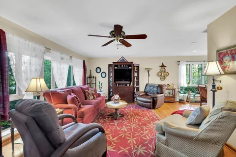 a living room with furniture a ceiling fan and a window