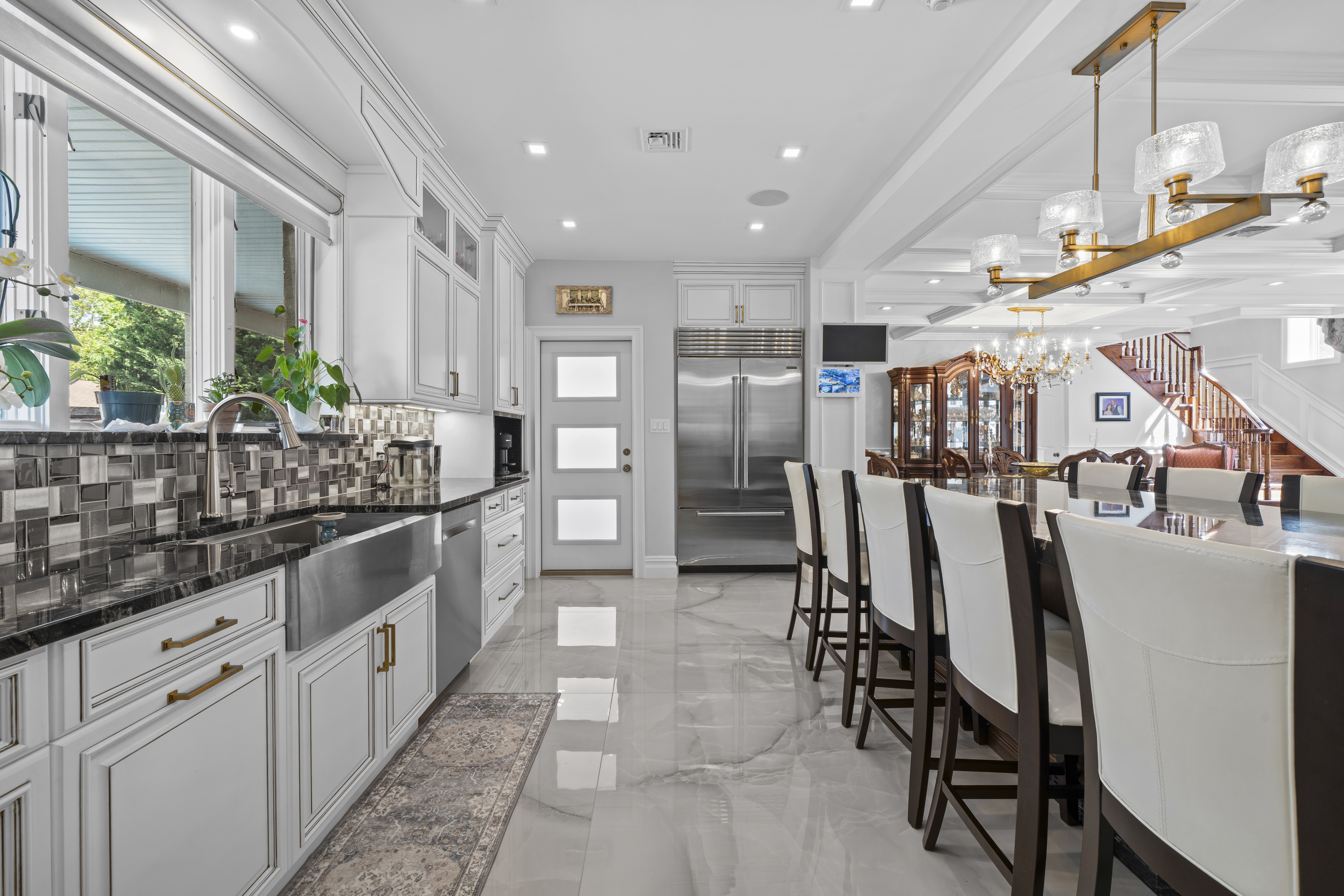 2253 East 64th Street Brooklyn, NY 11234 - Photo 10 of 45 a kitchen with stainless steel appliances kitchen island granite countertop a table chairs sink and cabinets