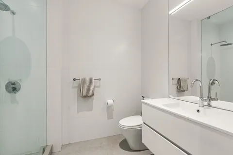 a bathroom with a sink a toilet and shower