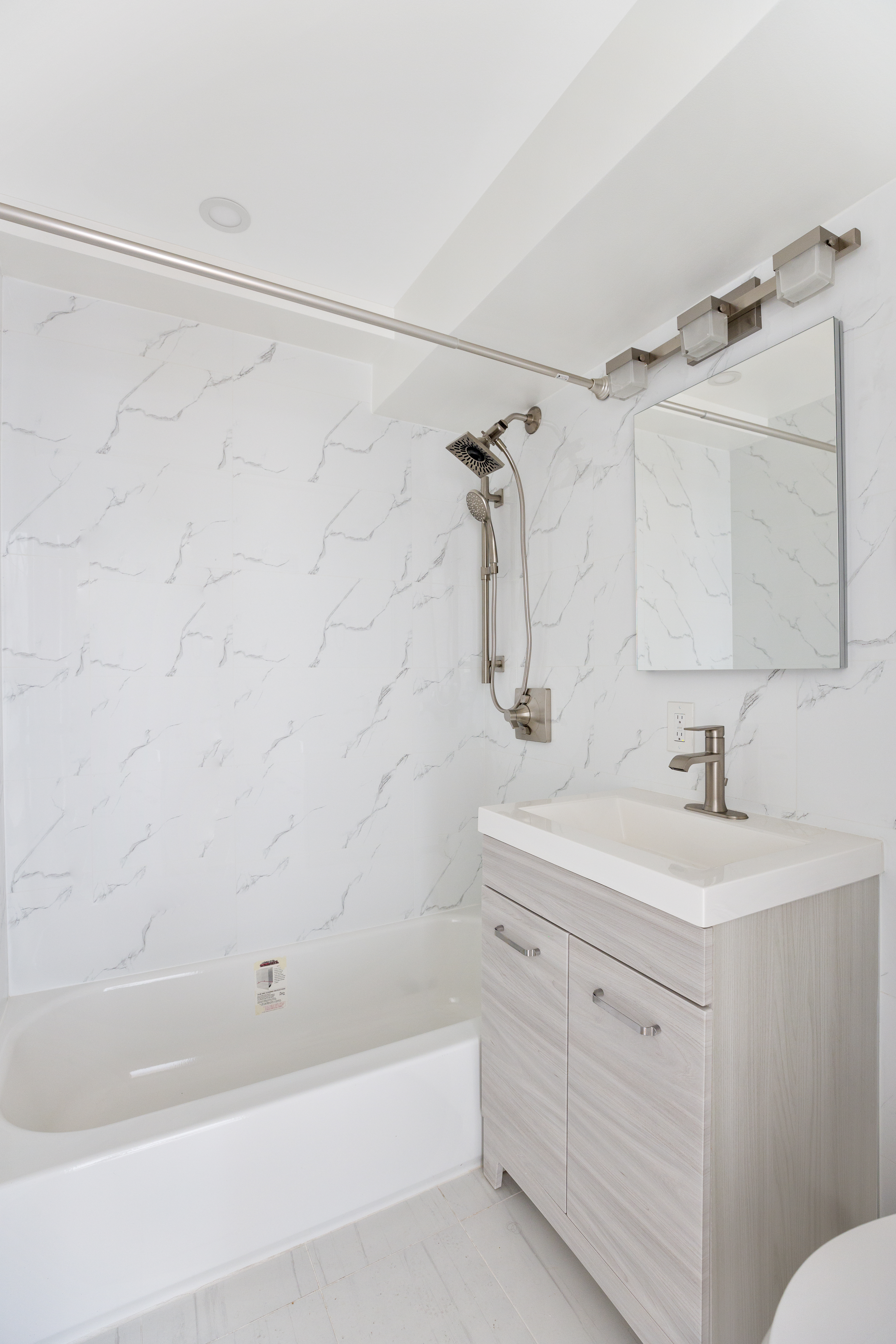 303 West 66th Street, Unit 15DE Manhattan, NY 10023 - Photo 5 of 9 a bathroom with a sink toilet vanity and shower