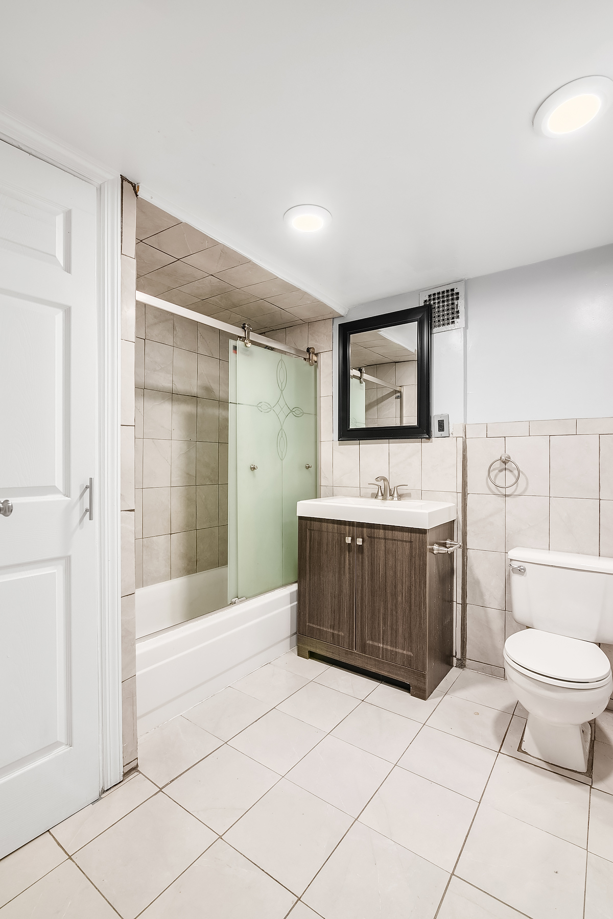 357 West 120th Street, Unit 1R Manhattan, NY 10027 - Photo 7 of 9 a bathroom with a tub a toilet a sink and mirror