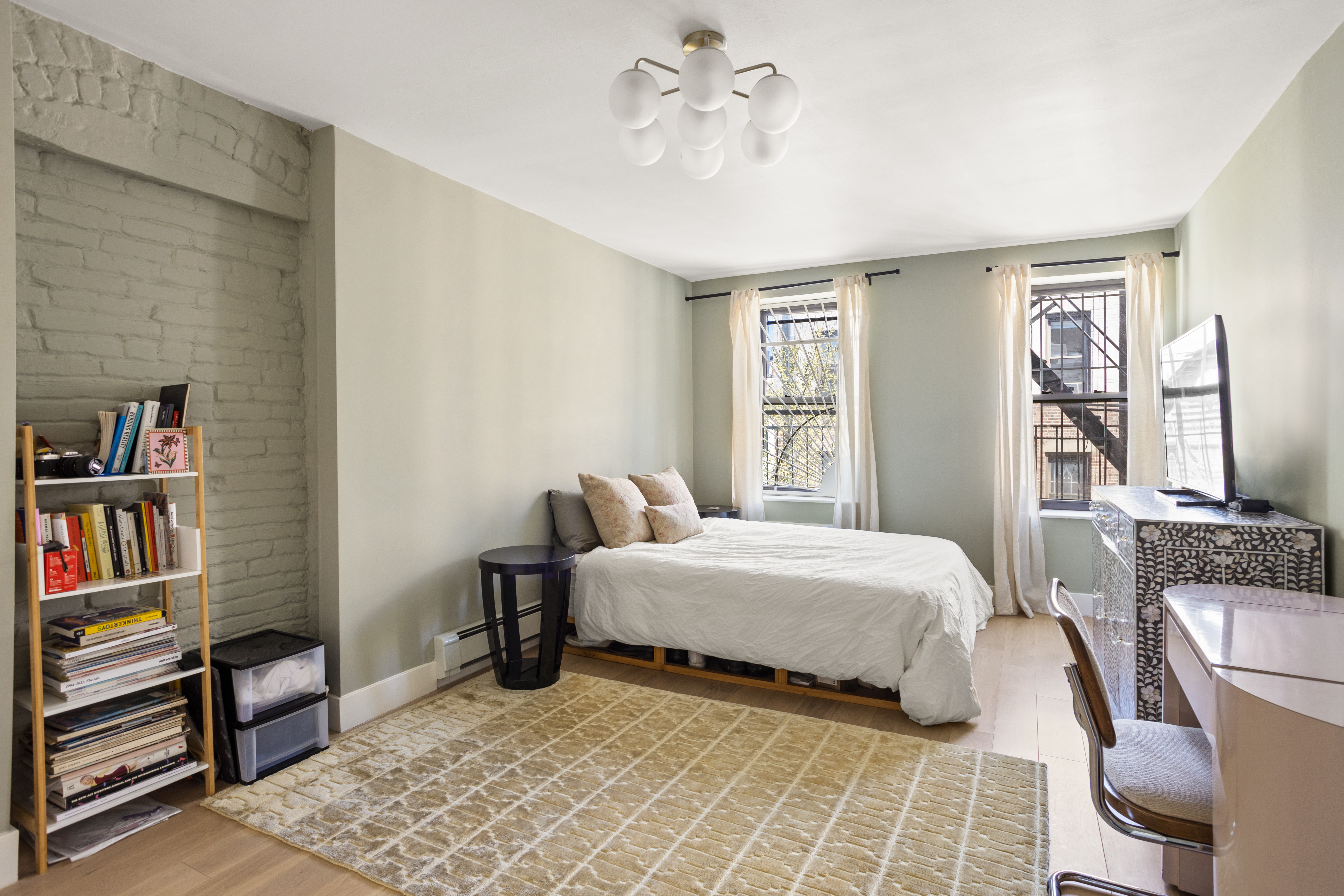 537 East 6th Street, Unit 5 Manhattan, NY 10009 - Photo 4 of 12 a bedroom with a bed a large window and book shelf