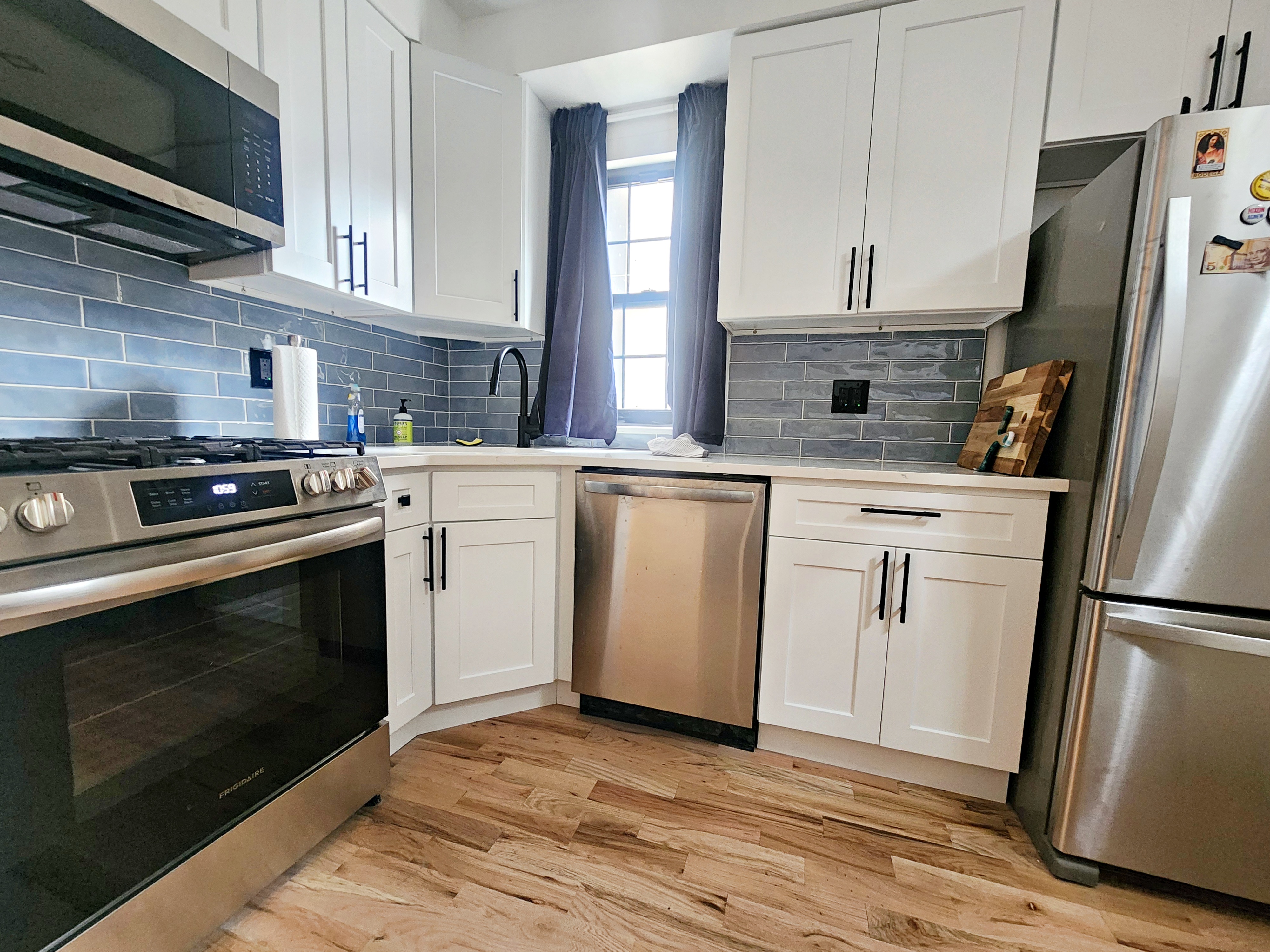 258 Devoe Street, Unit 1 Brooklyn, NY 11211 - Photo 4 of 12 a kitchen with white cabinets and stainless steel appliances