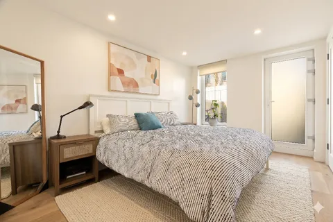 a bedroom with a bed and a painting on the wall