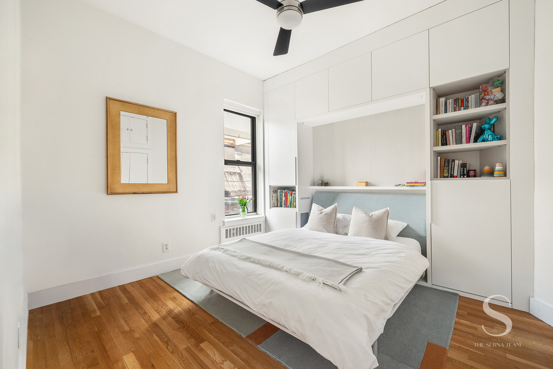 30 East 95th Street, Unit 6F Manhattan, NY 10128 - Photo 5 of 9 a bedroom with a bed and a book shelf