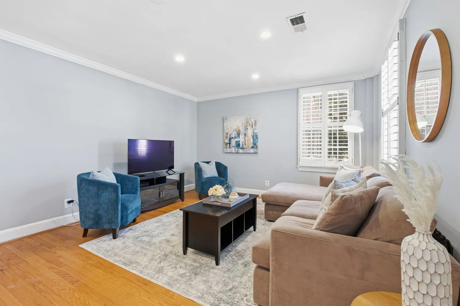 a living room with furniture a flat screen tv and a large window