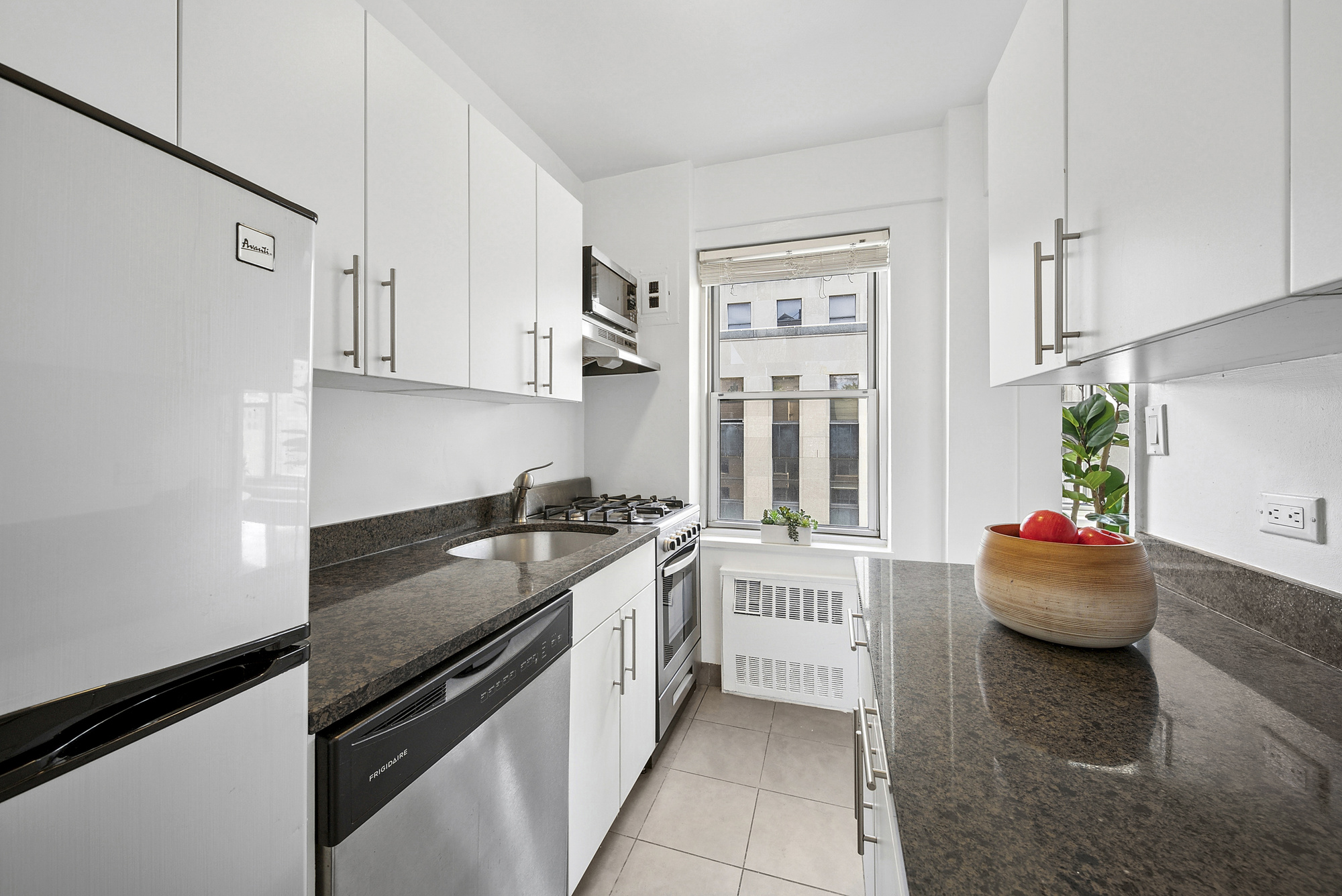 7 Lexington Avenue, Unit 12F Manhattan, NY 10010 - Photo 3 of 12 a kitchen with stainless steel appliances granite countertop a sink stove and cabinets