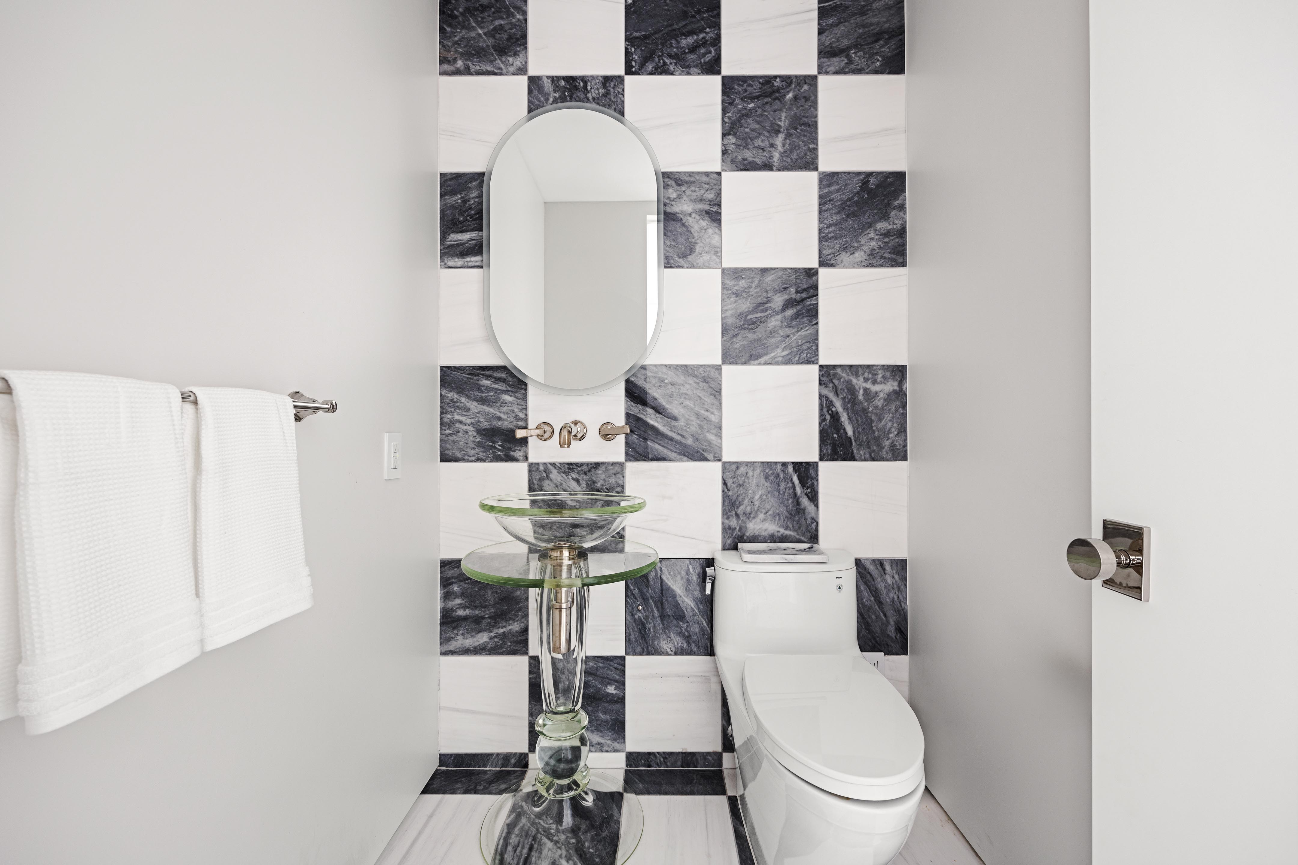 422 East 72nd Street, Unit 37AD Manhattan, NY 10021 - Photo 24 of 38 a white toilet sitting next to a bathroom sink and vanity