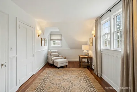 a bedroom with a bed wooden floor and window