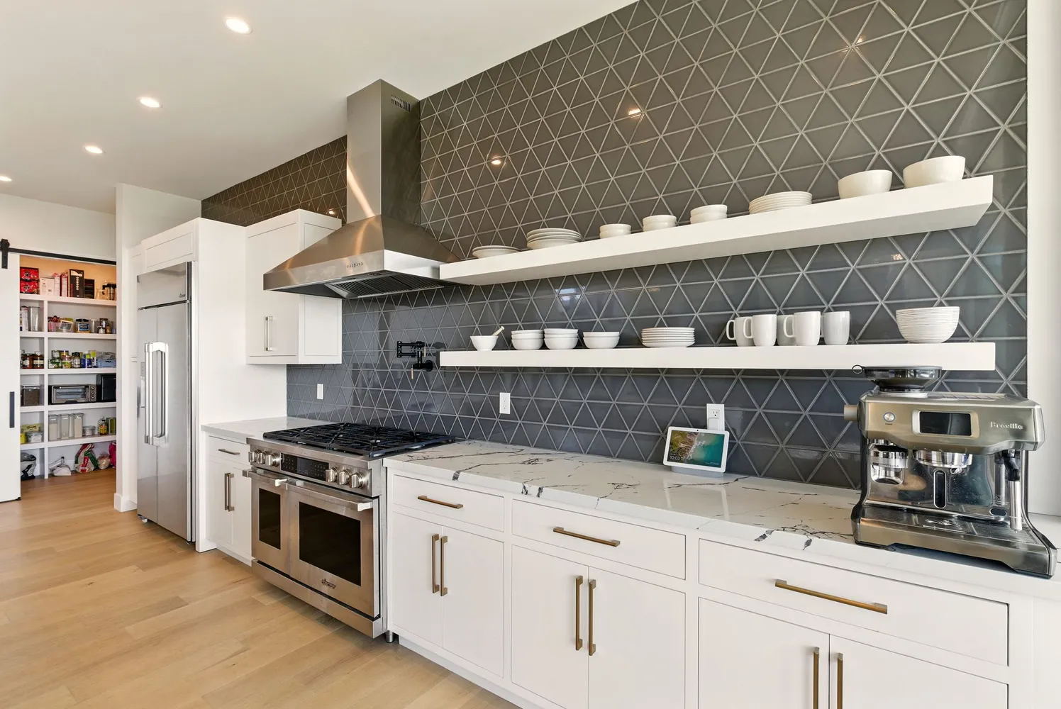 a kitchen with stainless steel appliances granite countertop a stove a refrigerator a oven a sink with a dining table and chairs