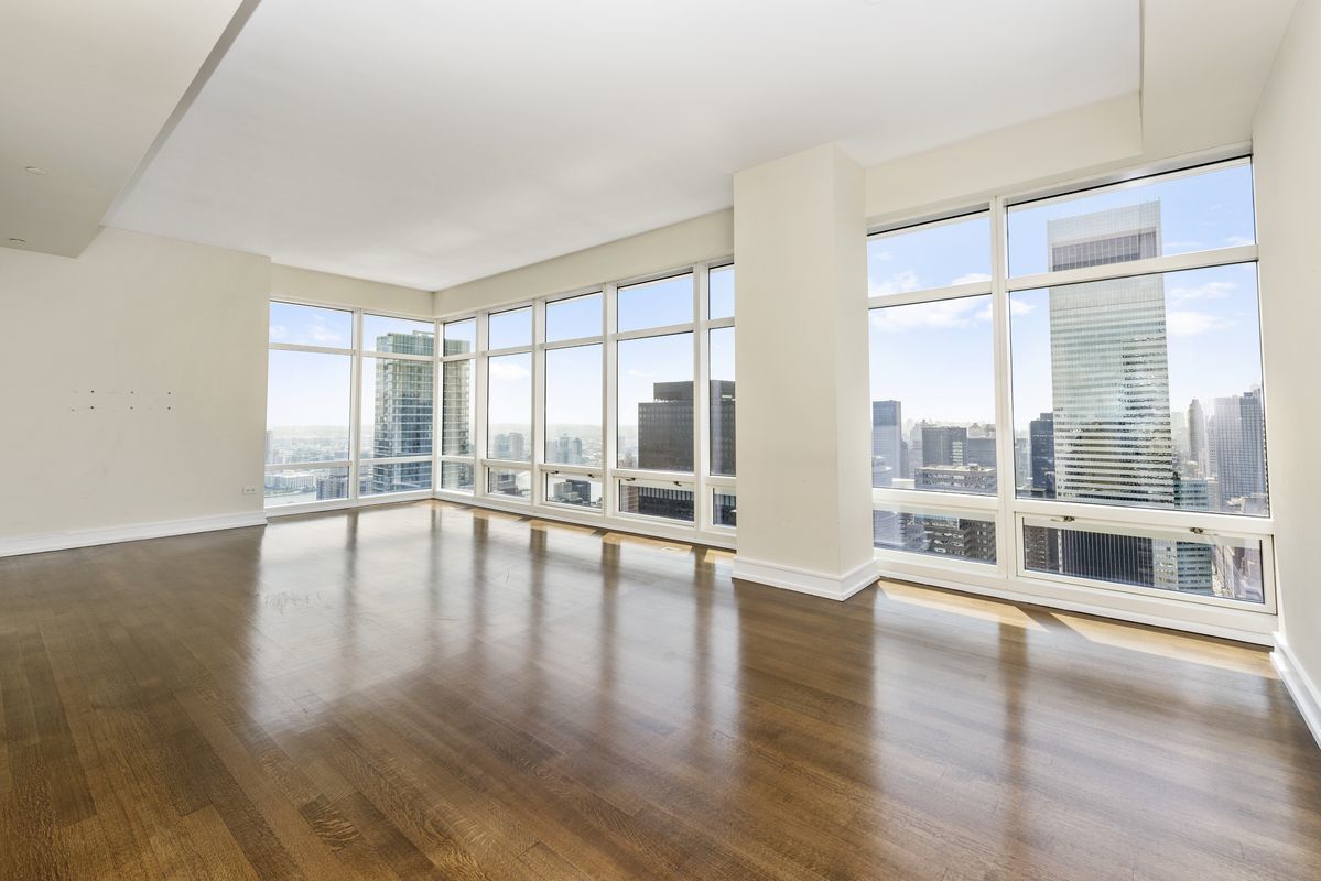 151 East 58th Street, Unit 39D Manhattan, NY 10022 - Photo 2 of 12 a view of an empty room with wooden floor and a window