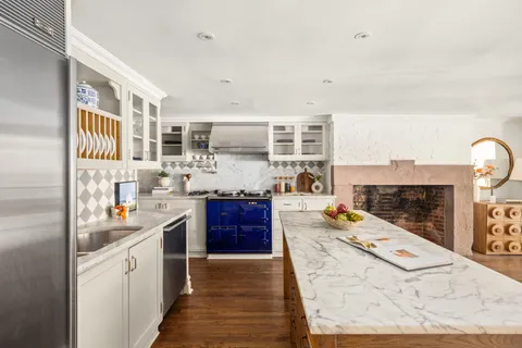 a kitchen with stainless steel appliances kitchen island granite countertop a stove and cabinets