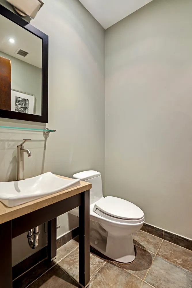 a bathroom with a sink a toilet and mirror
