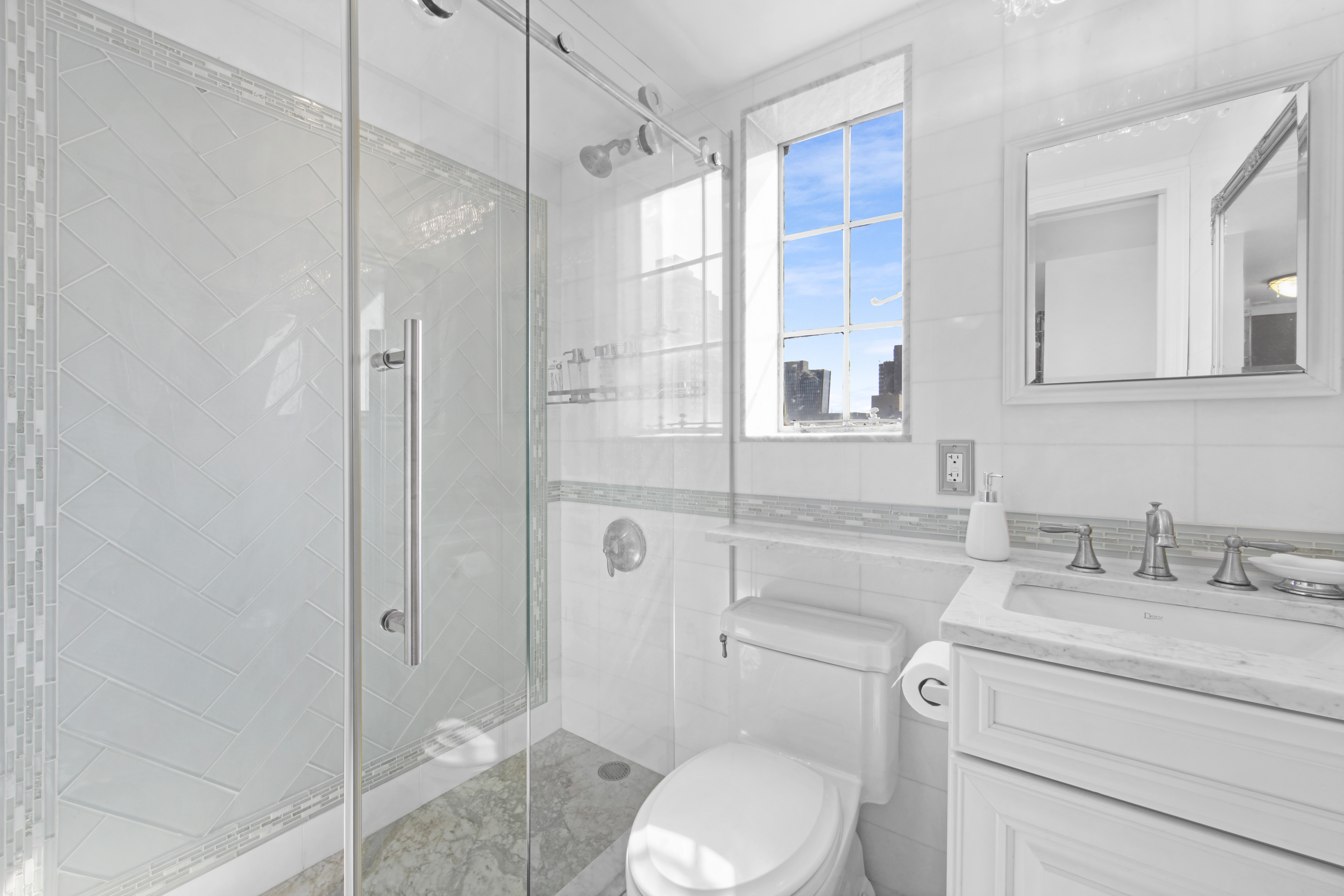 320 East 42nd Street, Unit 3012 Manhattan, NY 10017 - Photo 8 of 12 a bathroom with a granite countertop toilet sink and shower