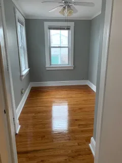 a view of empty room with window and wooden floor