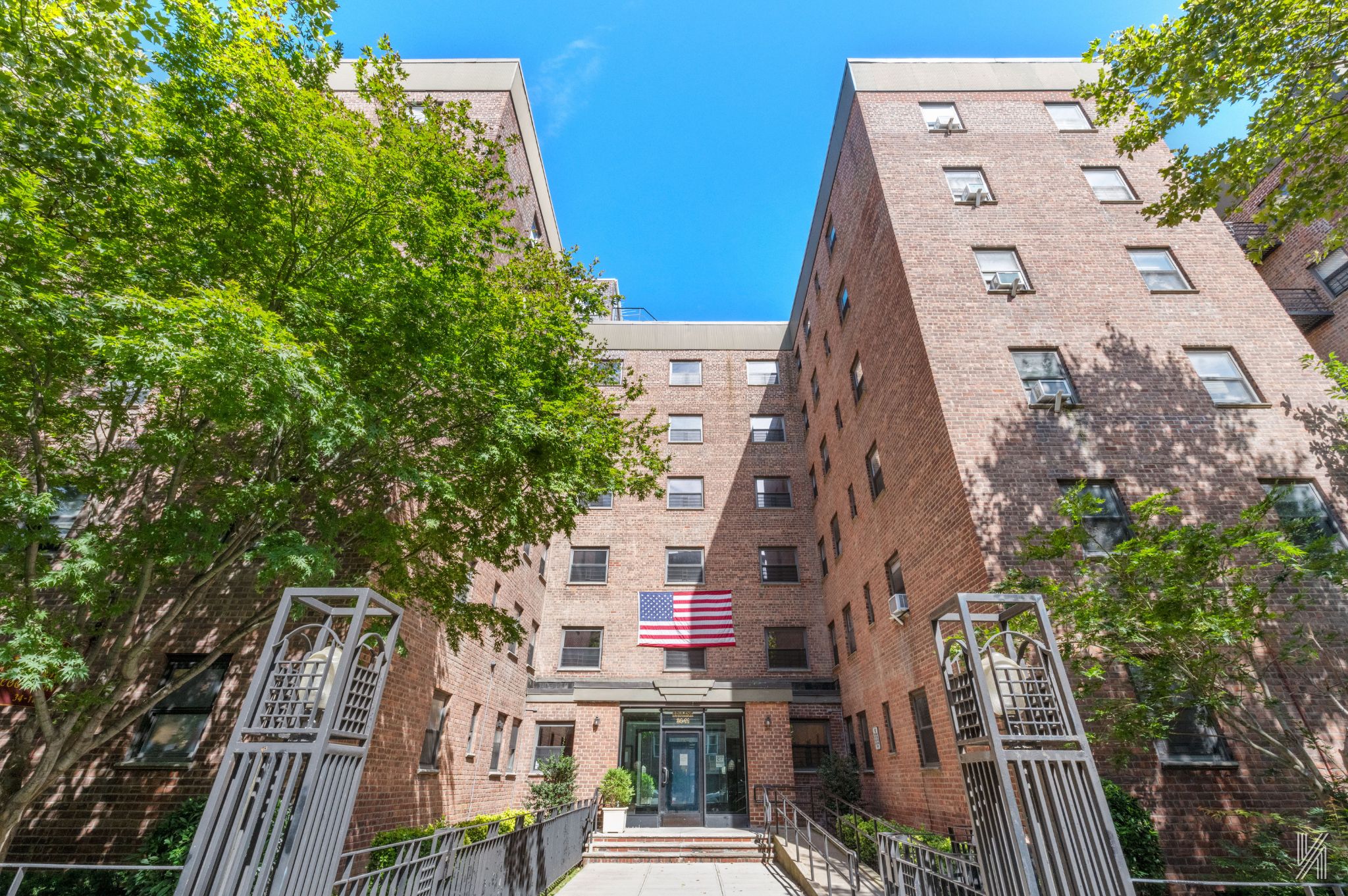 an aerial view of a residential apartment building with plants and wooden fence