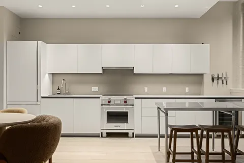 a kitchen with a table chairs refrigerator and cabinets